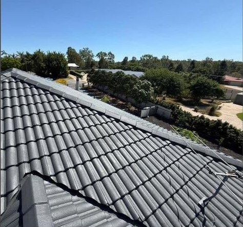 A restored concrete tile roof finished in charcoal membrane.